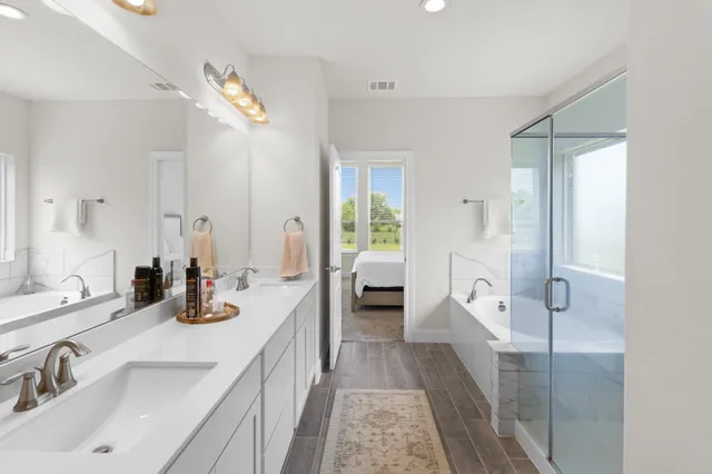 a spacious bathroom with a double vanity sink a mirror and a shower