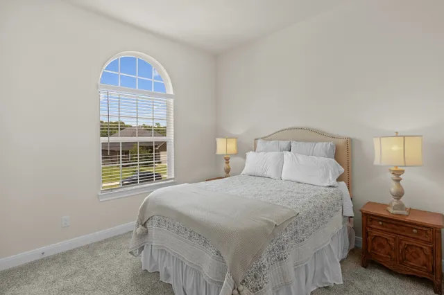 a bedroom with a bed a dresser and a window