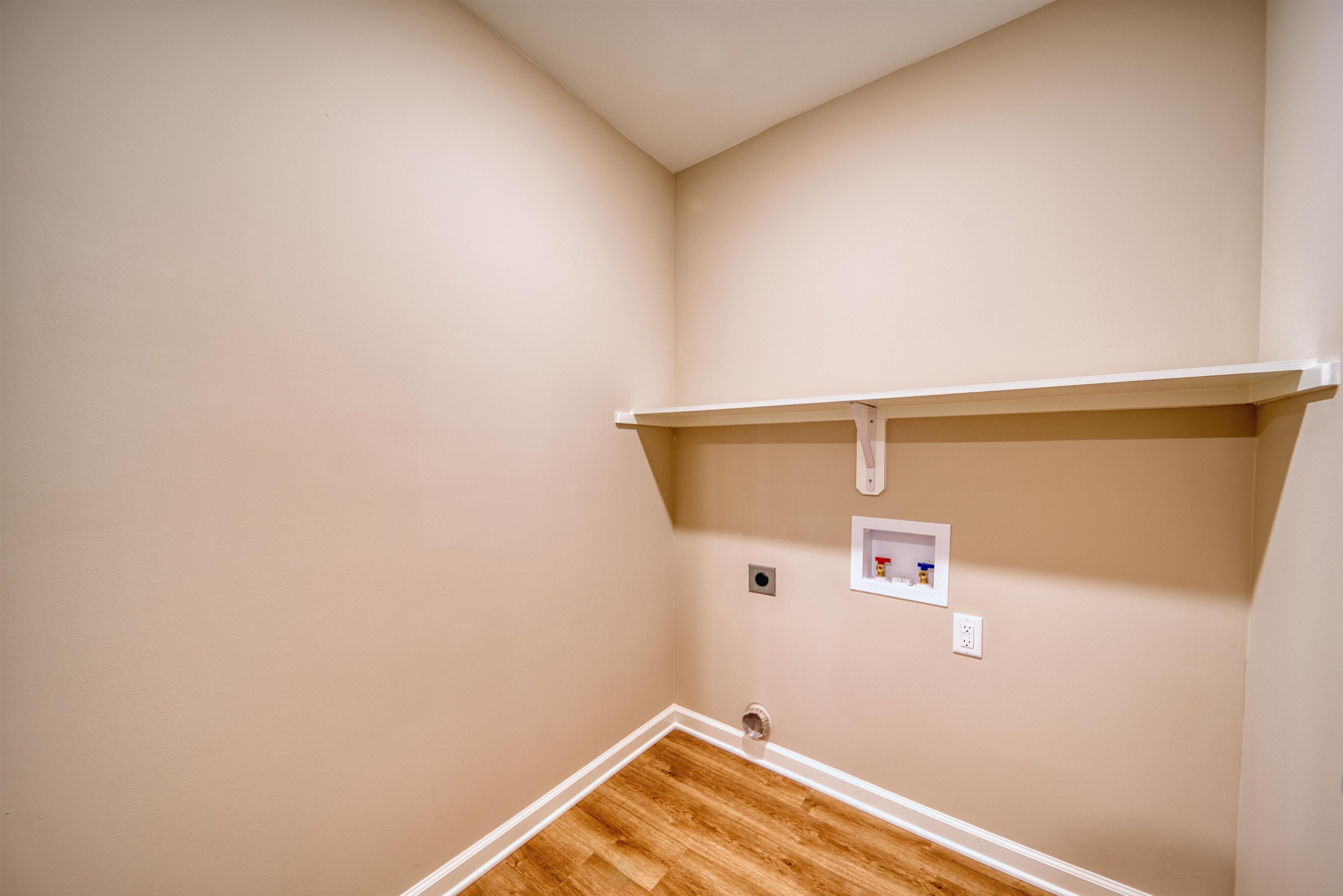 102 Stone Brook Cove Ripley, TN 38063 - Photo 28 of 32 Washroom featuring light wood-style floors, hookup for a washing machine, and electric dryer hookup