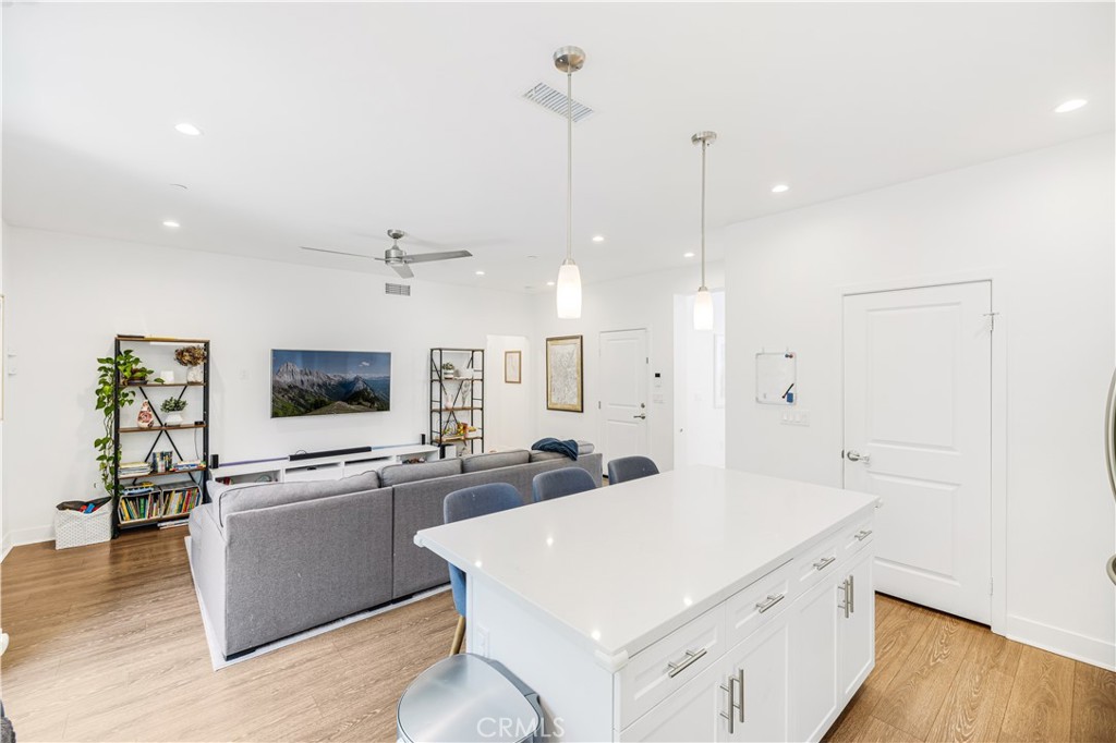 6747 Rhea Court Reseda, CA 91335 - Photo 5 of 26 a large white kitchen with a stove a sink a kitchen island with wooden floor and cabinets