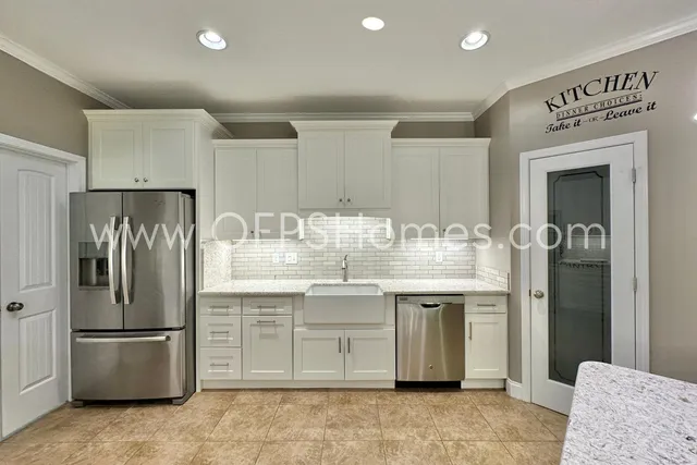 a kitchen with kitchen island a refrigerator sink and cabinets