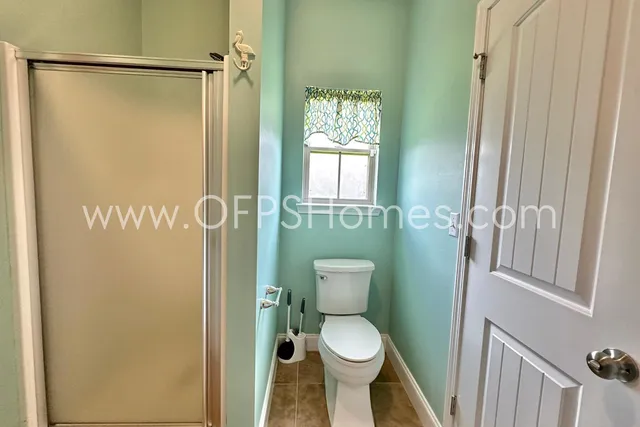 a bathroom with a toilet and a shower