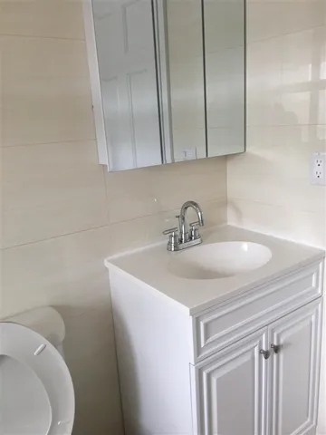 a bathroom with a sink a toilet and mirror