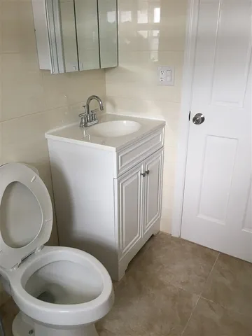 a bathroom with a toilet a sink and mirror