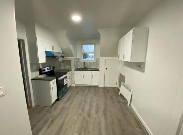 a kitchen with a sink a refrigerator a counter top space and cabinets