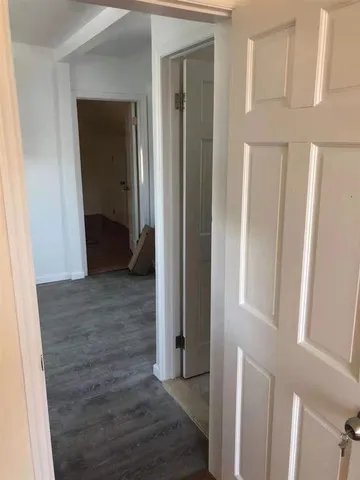 a view of a hallway with wooden floor and entryway
