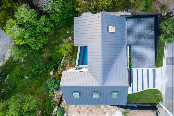 an aerial view of a house with swimming pool and garden