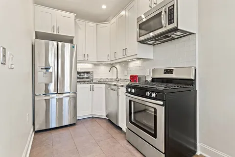a kitchen with stainless steel appliances white cabinets and a stove