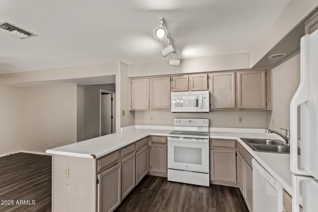 a kitchen with a sink a stove a refrigerator and white cabinets