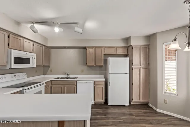 a kitchen with a refrigerator a sink and dishwasher with wooden floor