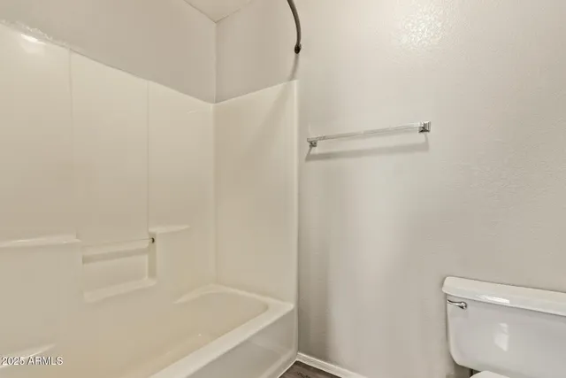 a white bath tub sitting next to a white toilet and a shower