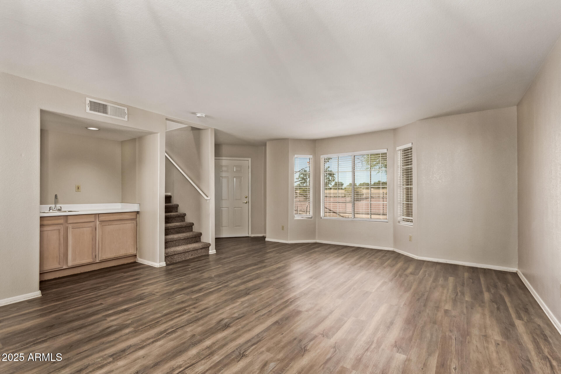 2875 West Highland Street, Unit 1112 Chandler, AZ 85224 - Photo 6 of 33 a view of an empty room with a window and wooden floor