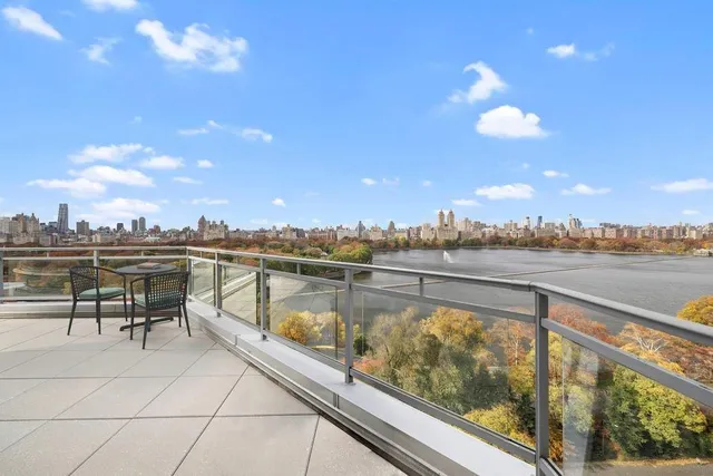 a view of a balcony with dining table and chairs