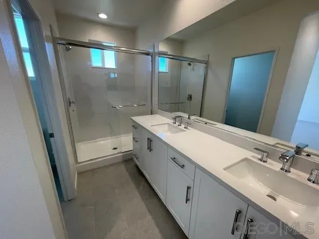 a bathroom with a double vanity sink mirror double and shower