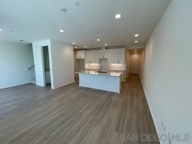 a view of kitchen with kitchen island wooden floor center island and stainless steel appliances