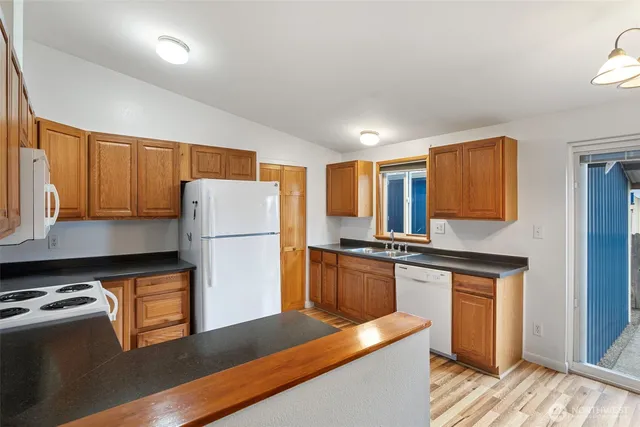 a kitchen with stainless steel appliances granite countertop a refrigerator a stove a sink and a microwave