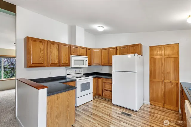 a kitchen with stainless steel appliances granite countertop a refrigerator a stove a sink and a microwave