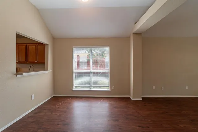 a view of a livingroom with wooden floor and window