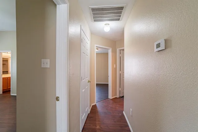 a view of a hallway with wooden floor