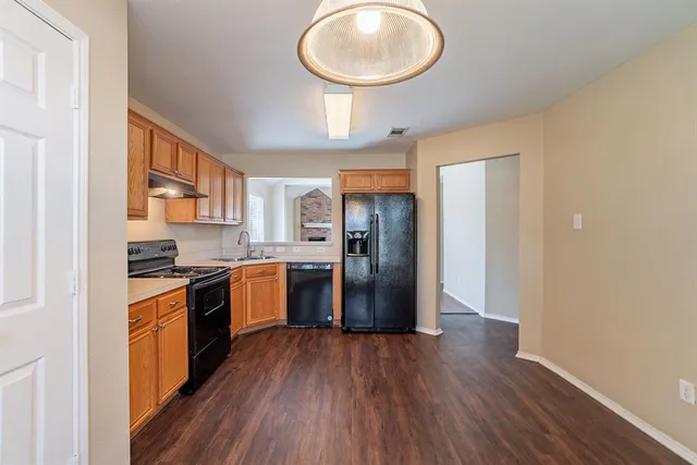 a kitchen with stainless steel appliances granite countertop a stove a refrigerator and a wooden floors