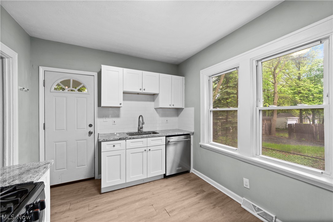 1062 Yellowstone Road Cleveland Heights, OH 44121 - Photo 10 of 29 Kitchen featuring stainless steel dishwasher, plenty of natural light, and light wood-type flooring