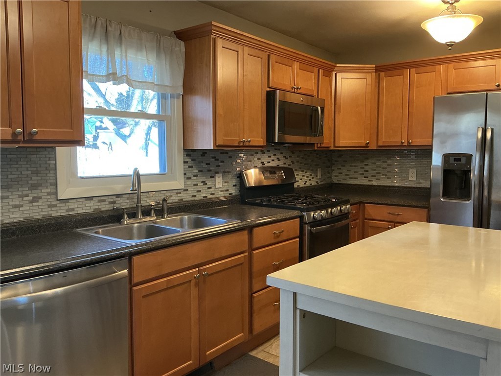 1850 Merle Road Salem, OH 44460 - Photo 7 of 35 Kitchen with stainless steel appliances, backsplash, wood finish cabinets, and dark countertops