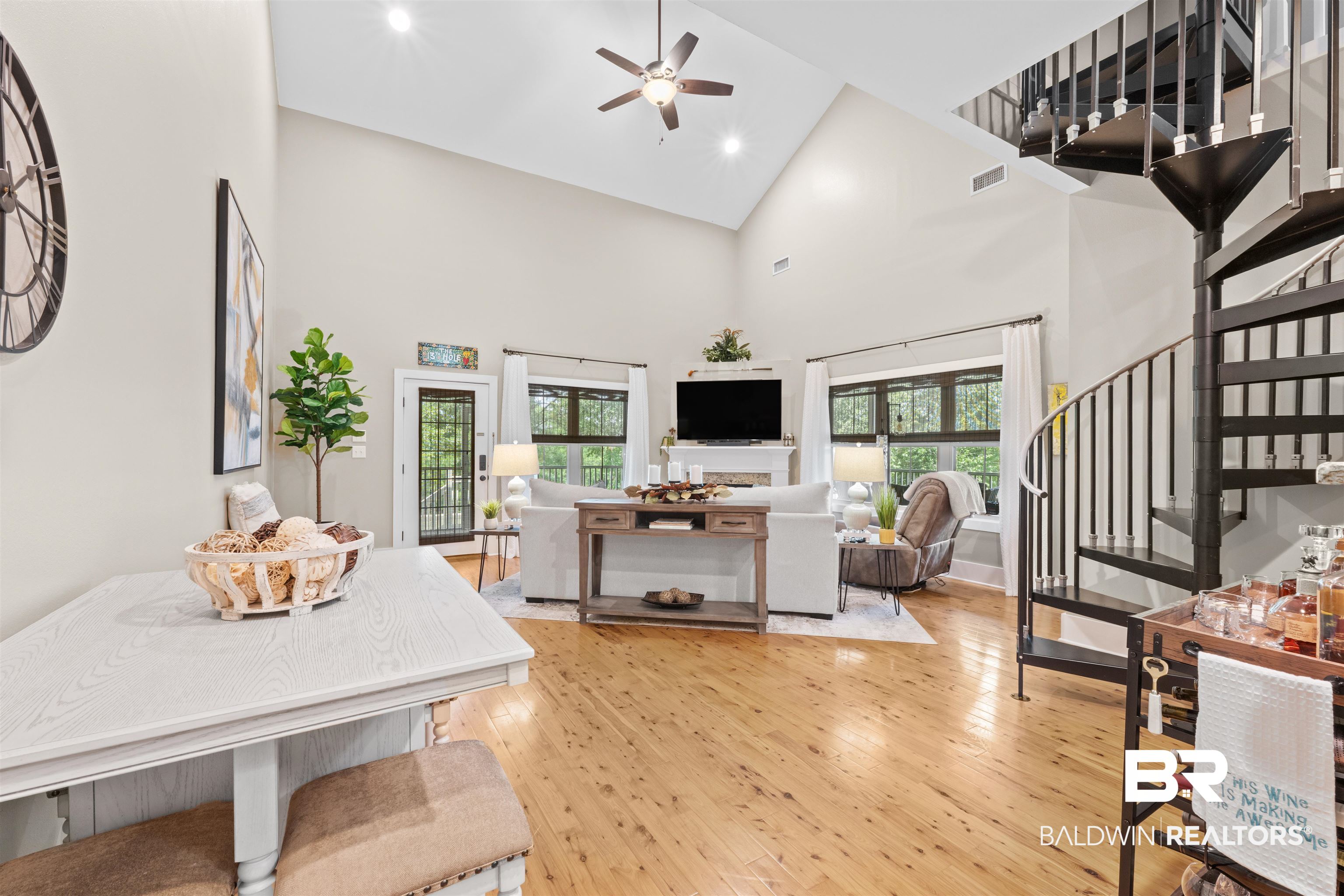 32700 Steelwood Ridge Road, Unit D Loxley, AL 36551 - Photo 8 of 41 Expansive living area featuring vaulted ceilings, wood-finish flooring, and a striking black spiral staircase