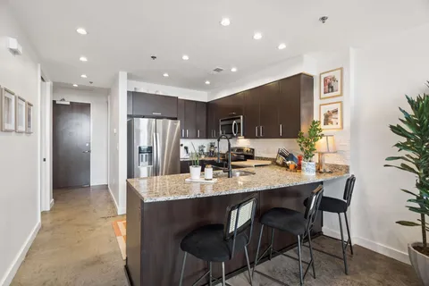 a kitchen with refrigerator and chairs
