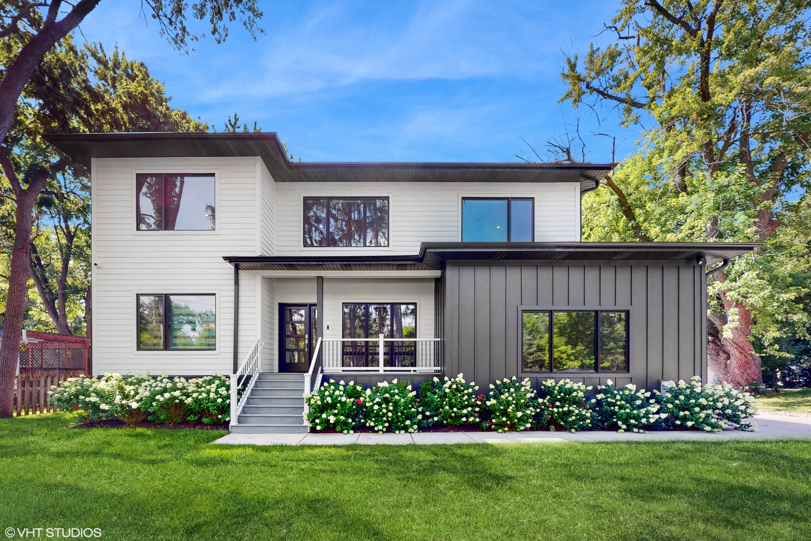a front view of a house with a garden and plants