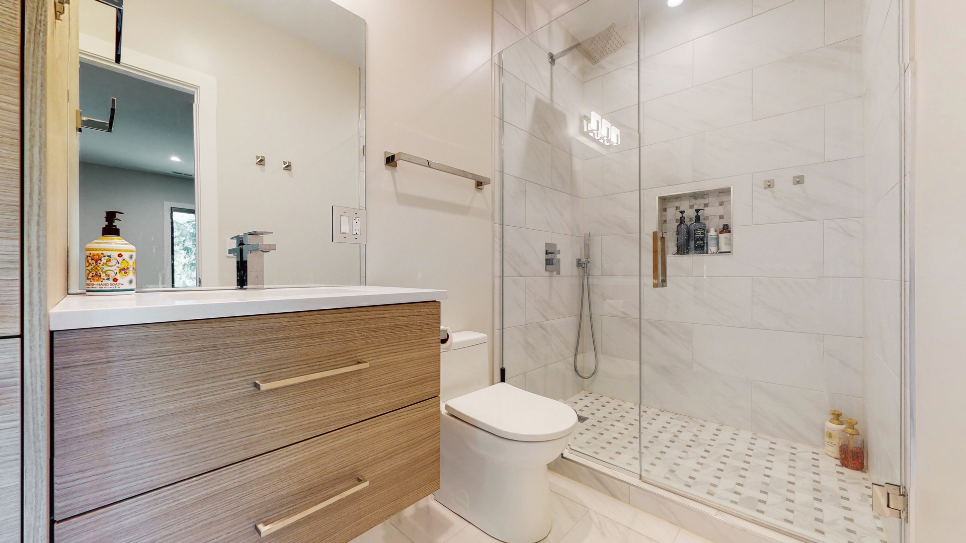 1 A Half Day Road Lincolnshire, IL 60069 - Photo 24 of 37 a bathroom with a sink a toilet a mirror and shower