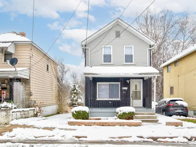 a front view of a house with a yard and seating space