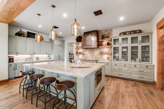 a large kitchen with kitchen island white cabinets and stainless steel appliances