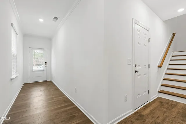 a view of a hallway with wooden floor and entryway