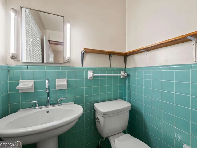 a bathroom with a toilet sink and mirror