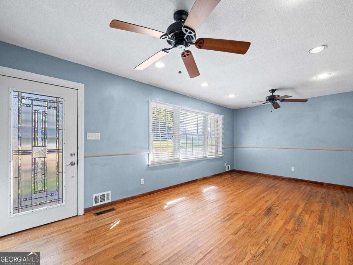 372 Hilltop Way Toccoa, GA 30577 - Photo 2 of 38 a view of an empty room with a window and wooden floor