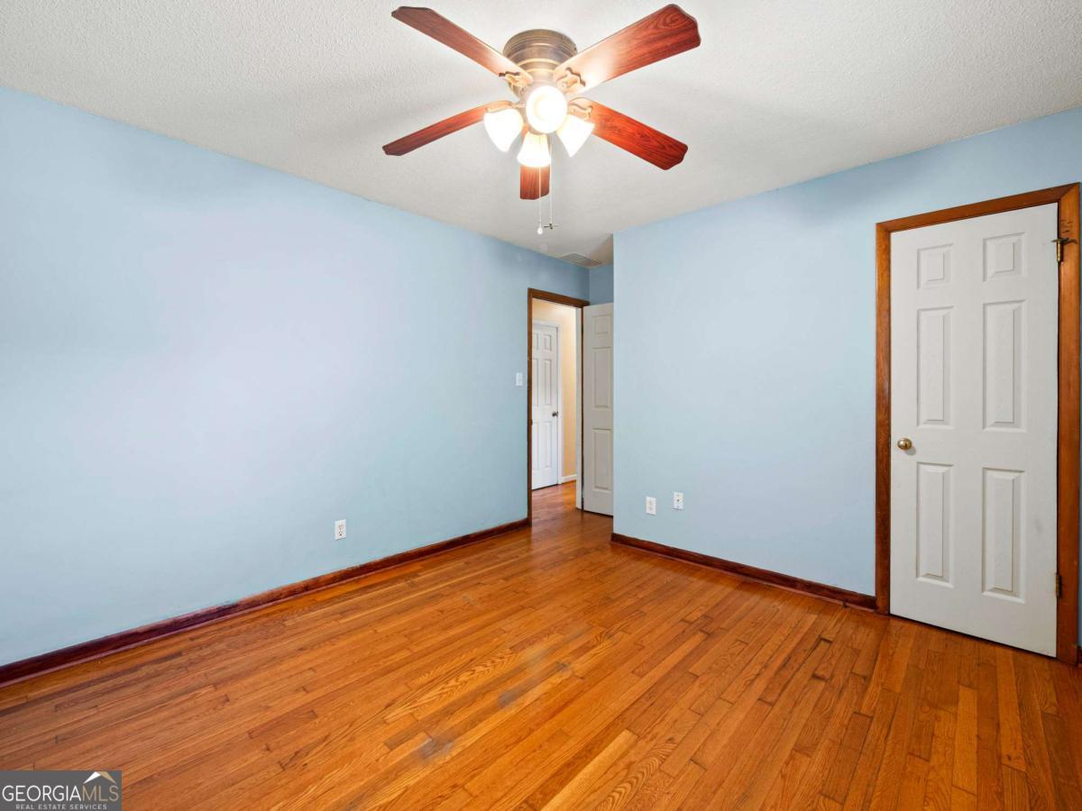 372 Hilltop Way Toccoa, GA 30577 - Photo 23 of 38 an empty room with wooden floor and a ceiling fan