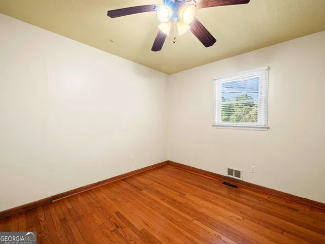 an empty room with a window and wooden floor
