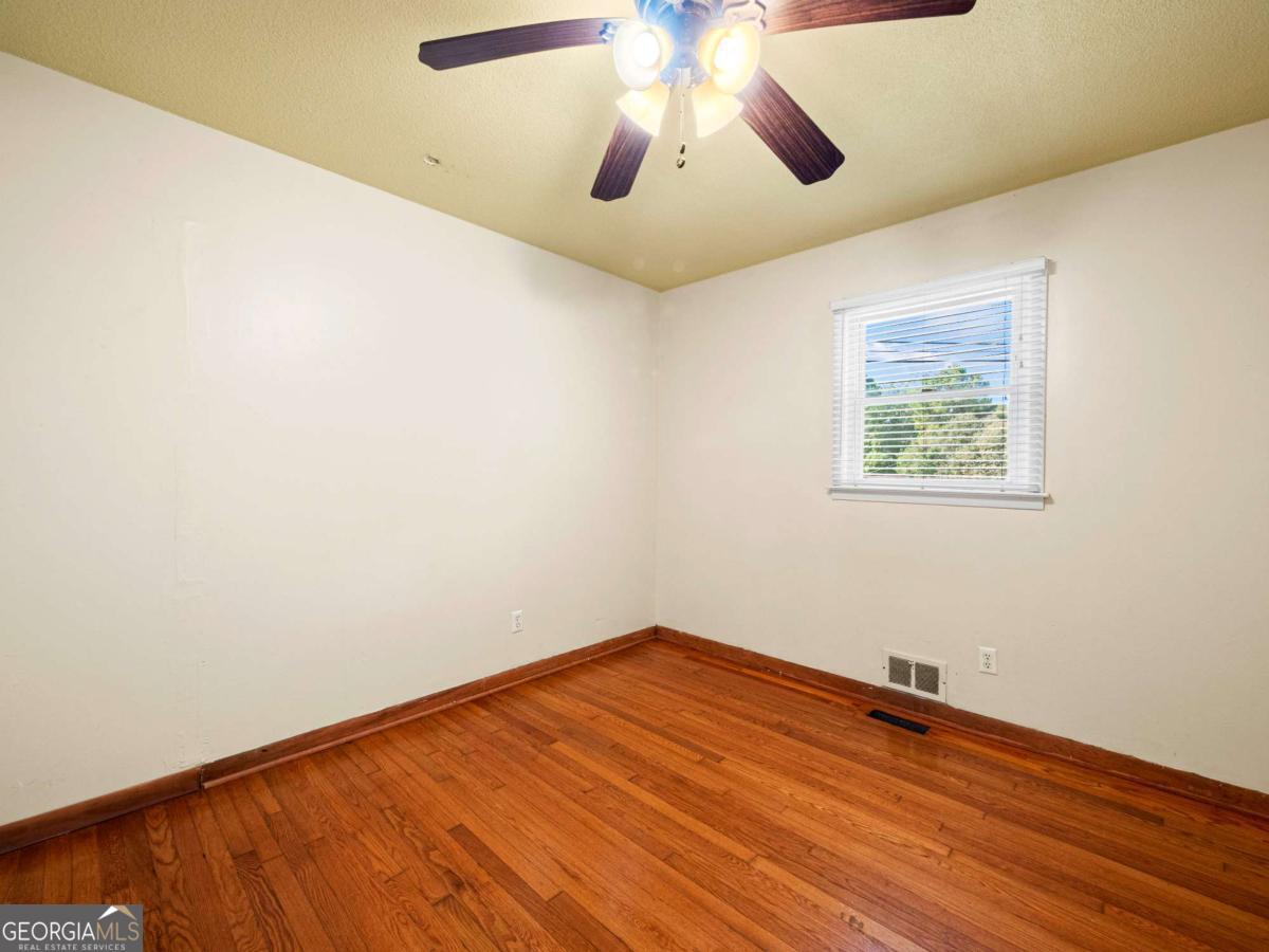 372 Hilltop Way Toccoa, GA 30577 - Photo 24 of 38 an empty room with a window and wooden floor