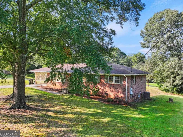 a view of a house with a yard and sitting area
