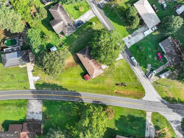 an aerial view of residential houses with outdoor space and trees
