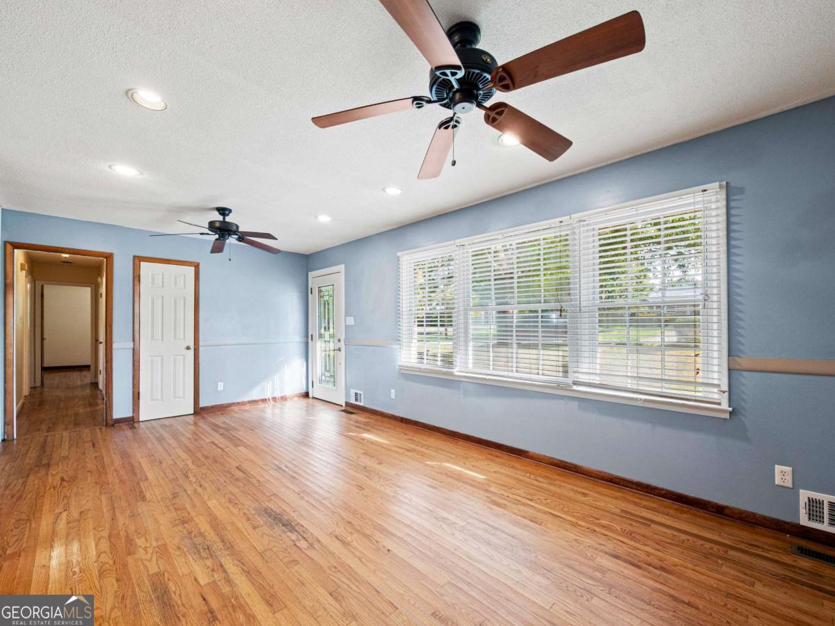 372 Hilltop Way Toccoa, GA 30577 - Photo 5 of 38 a view of an empty room with a window and wooden floor