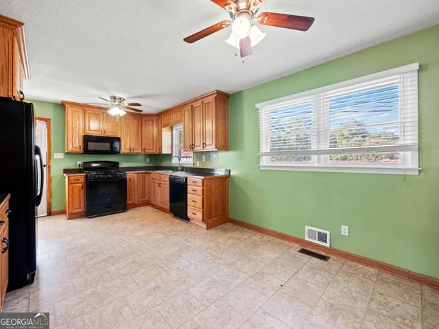 a kitchen with stainless steel appliances granite countertop a refrigerator and a stove top oven