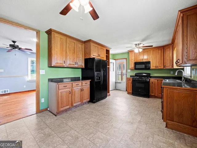 a kitchen with stainless steel appliances granite countertop a refrigerator a stove top oven a sink and dishwasher