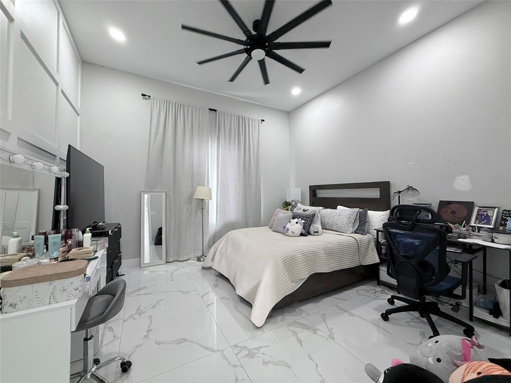 7403 Edgemere Road Tampa, FL 33625 - Photo 18 of 41 a bedroom with a bed a desk and chair