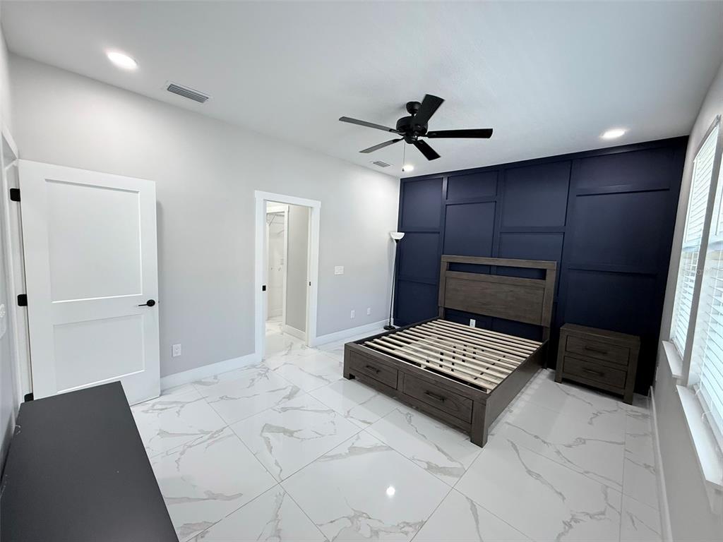 7403 Edgemere Road Tampa, FL 33625 - Photo 20 of 41 a bedroom with a bed and a ceiling fan