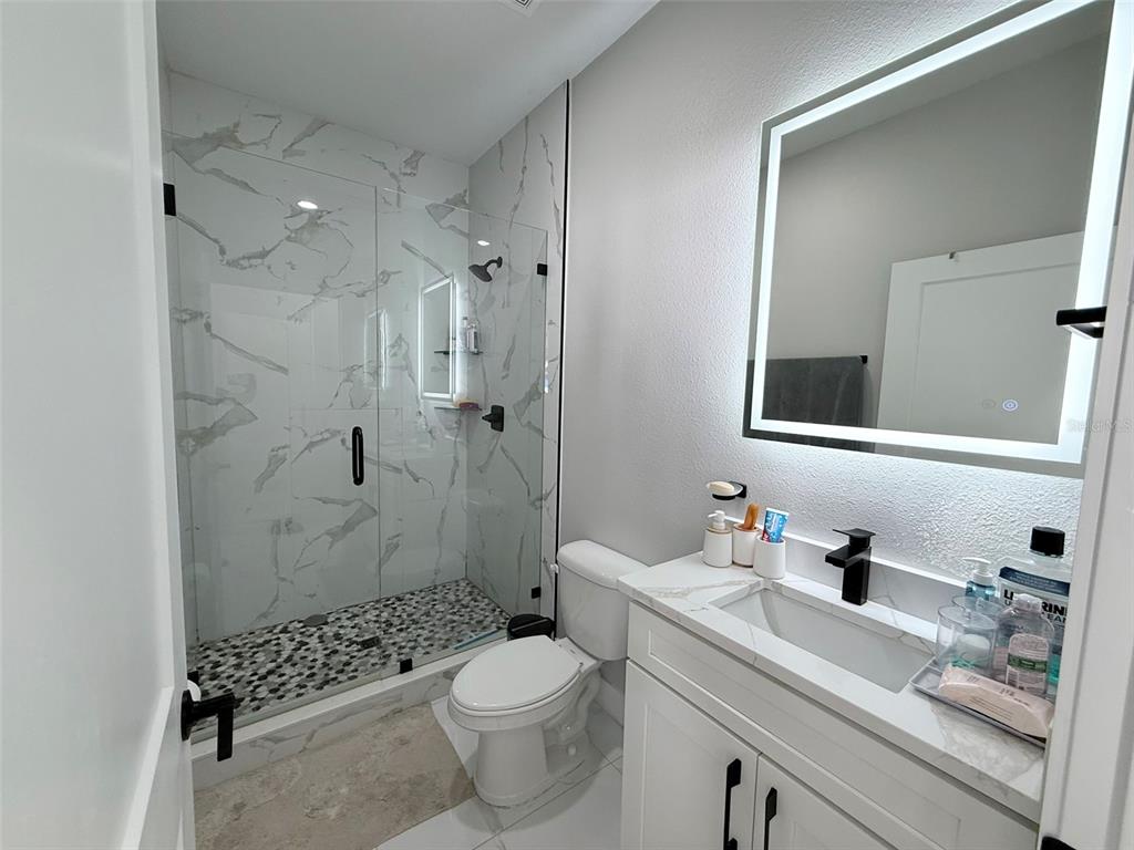 7403 Edgemere Road Tampa, FL 33625 - Photo 31 of 41 a bathroom with a sink a toilet and shower