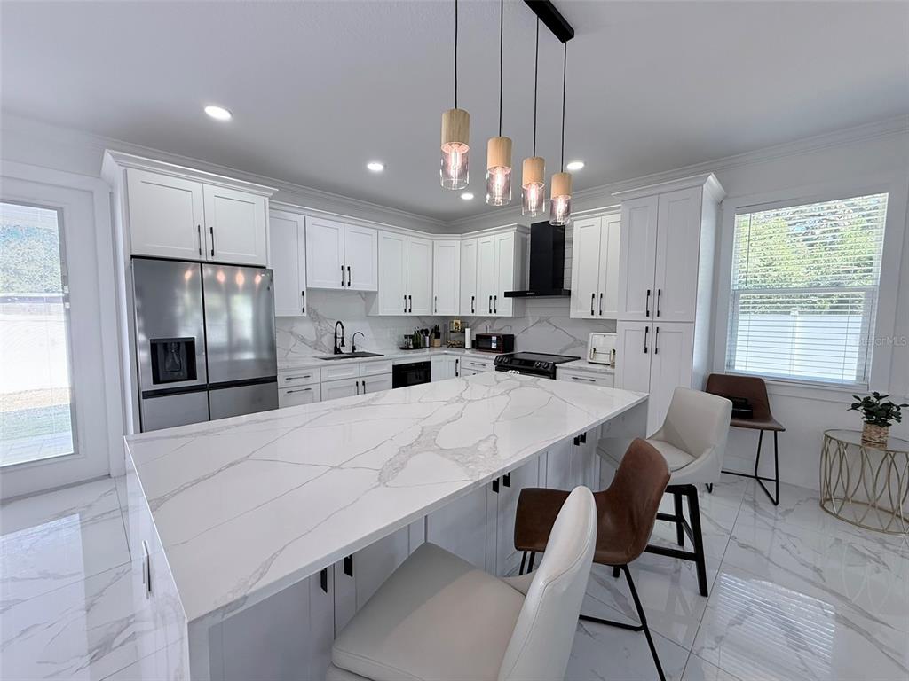 7403 Edgemere Road Tampa, FL 33625 - Photo 4 of 41 a large kitchen with cabinets chairs and stainless steel appliances