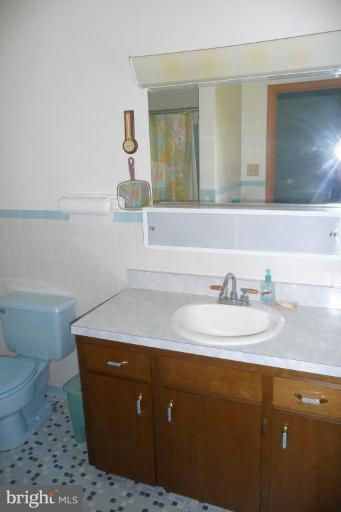 1130 Cox Road Huntingtown, MD 20639 - Photo 18 of 30 a bathroom with a granite countertop sink a toilet and mirror