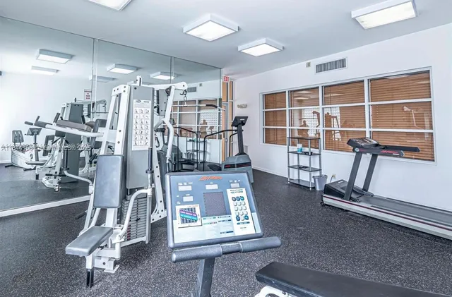 a room with gym equipment and a view of living room