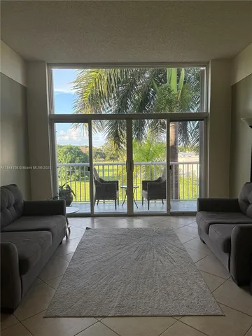 a living room filled with furniture and a large window